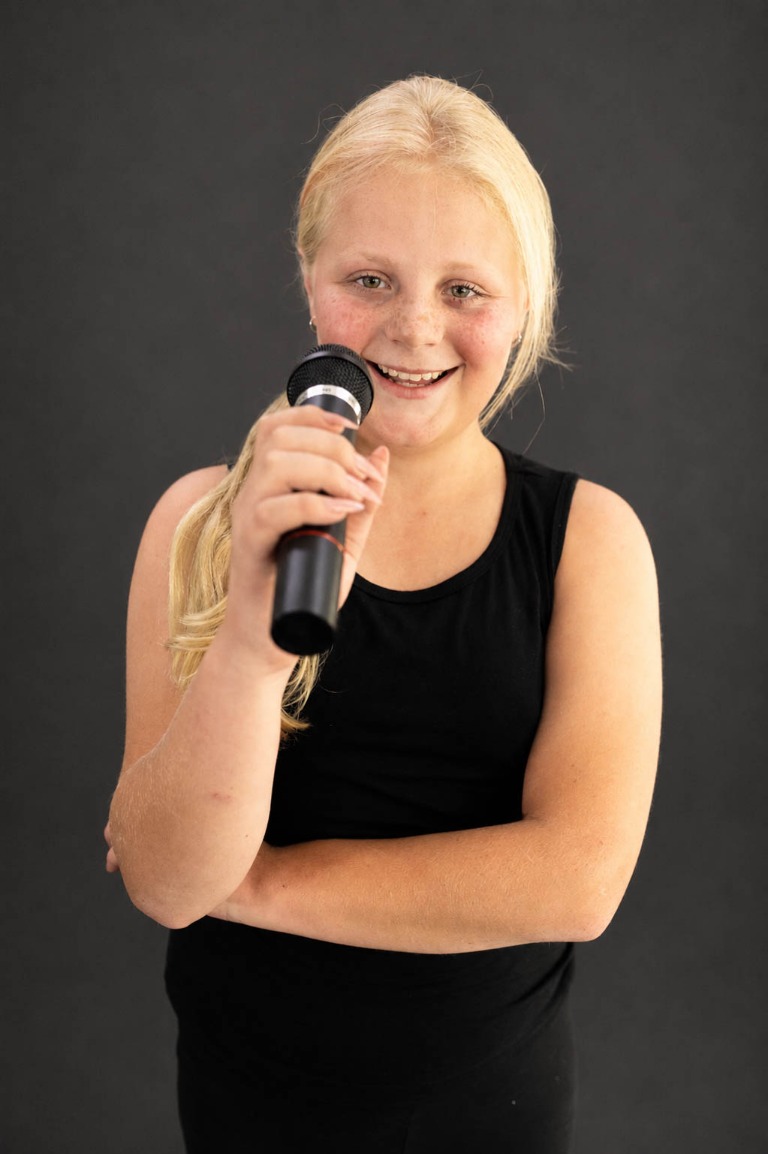Belong student singing into a microphone