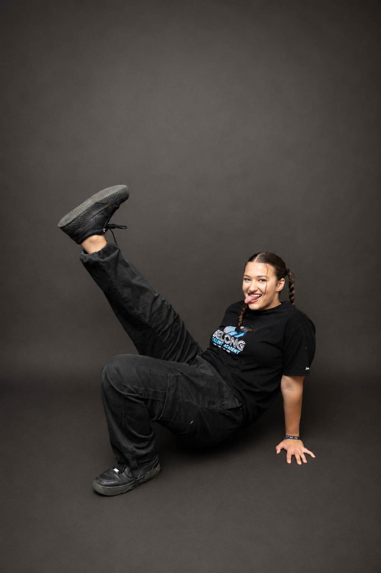 Belong dancer smiling while performing a floor pose